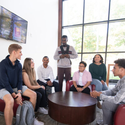 Group of students smiling in Lyons center lobby