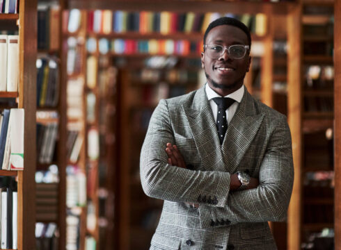 Male Education major stands in the library