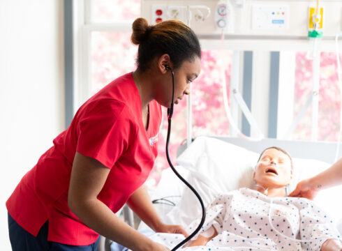 A nursing student at New England College takes a patient's blood pressure in the nursing lab.